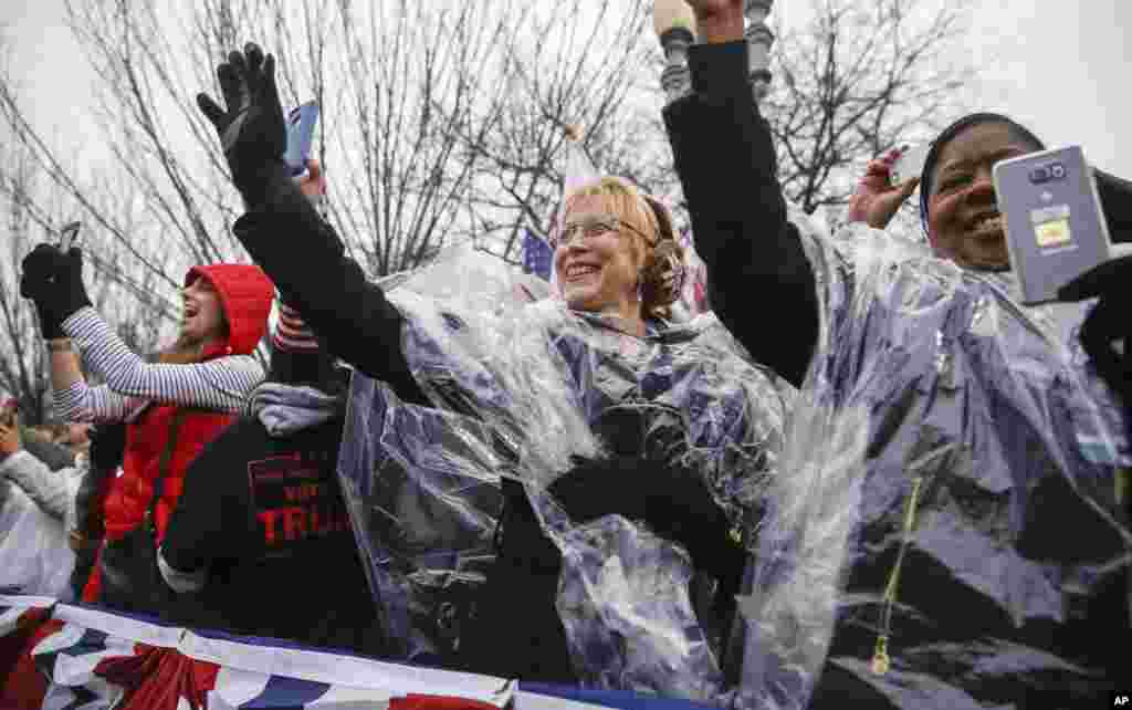 Members of the crowd wave as President Donald Trump, accompanied by first lady Melania Trump, walks in his inaugural parade on Pennsylvania Avenue in Washington, Jan. 20, 2017.