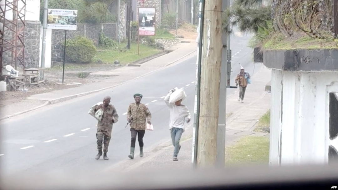This video grab made from AFP TV footage in Goma on Jan.27, 2025, shows armed men walking in the streets of the city, some carrying their belongings.
