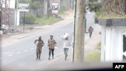 This video grab made from AFP TV footage in Goma on Jan.27, 2025, shows armed men walking in the streets of the city, some carrying their belongings.