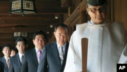 Seorang pendeta Shinto memimpin para anggota parlemen Jepang saat berziarah ke kuil perang Yasukuni di Tokyo, hari Selasa (22/4). 