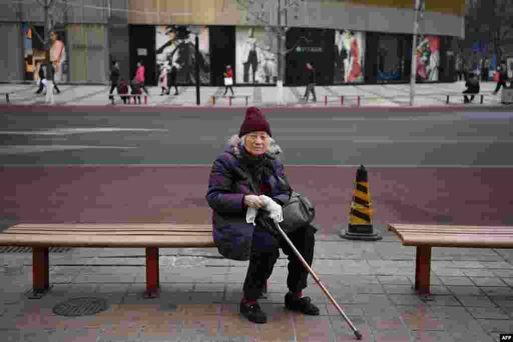 2018年3月7日，一名老年妇女在北京一家购物街的座位上休息。中国人口结构急剧老龄化，主要原因是1980年代初开始的独生子女政策。