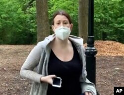 FILE - This image made from May 25, 2020 video provided by Christian Cooper, shows Amy Cooper with her dog talking to Christian Cooper in Central Park in New York.