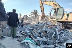 Members of Iraqi Shiite Popular Mobilization Forces clean the rubble after a U.S. airstrike in al-Qaim, Iraq, on Feb. 3, 2024.