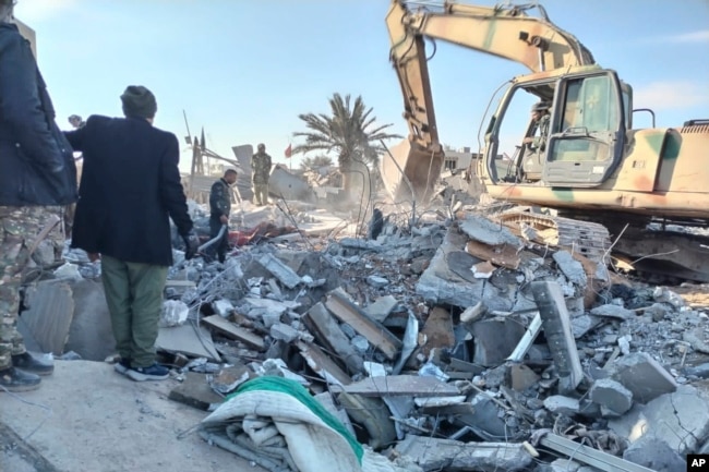 Members of Iraqi Shiite Popular Mobilization Forces clean the rubble after a U.S. airstrike in al-Qaim, Iraq, on Feb. 3, 2024.