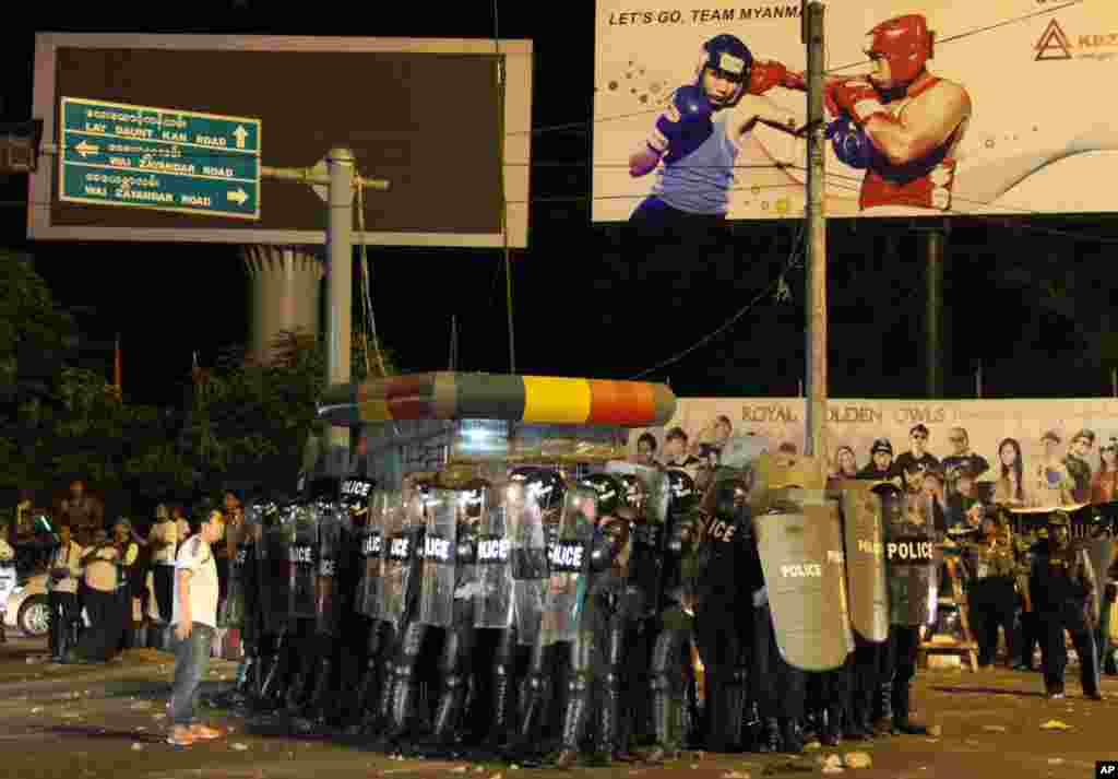 Polisi anti huru-hara Burma berjaga-jaga di stadion Thuwunna di Rangoon, setelah para pendukung timnas Burma yang marah membakar poster dan bendera karena timnas Burma kalah 0-1 dari timnas Indonesia pada pertandingan SEA Games di Rangoon.