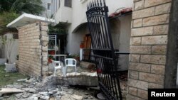 A general view of the damage caused by a bomb blast is seen at the gate of the Iranian ambassador's residence in Tripoli, Libya, Feb. 22, 2015.