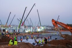 FILE - Construction workers labor at the site of the Huoshenshan temporary field hospital being built in Wuhan in central China's Hubei Province, Jan. 30, 2020.