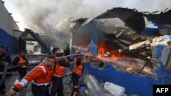 Palestinian firefighters douse a huge fire at the Foamco mattress factory east of Jabalia in the northern Gaza Strip, on May 17, 2021. (Photo by MAHMUD HAMS / AFP)