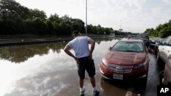 Robert Briscoe checks the damage to his flooded car along Interstate 45 in Houston, May 26, 2015. 