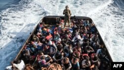 Un garde-côte libyen surveille 147 immigrants clandestins qui essayaient d'atteindre l'Europe au large de la ville côtière de Zawiyah, à 45 kilomètres à l'ouest de la capitale Tripoli, le 27 juin 2017.