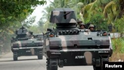 FILE - Philippine soldiers in armoured vehicles patrol a highway in Mamasapano, Maguindanao, southern Philippines, March 31, 2015.