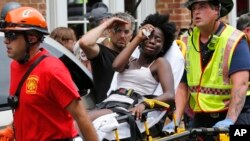 Rescatistas ayudan a una mujer herida luego que un auto se lanzó contra un grupo de contramanifestantes que protestaban la presencia de nacionalistas blancos en Charlottesville, Virginia.