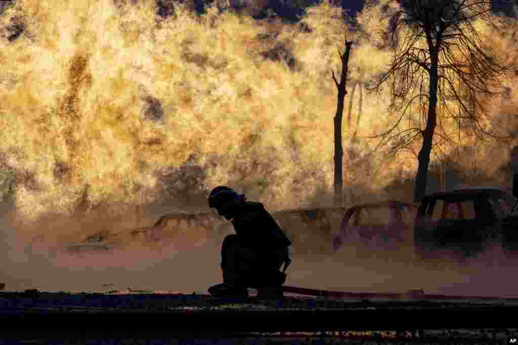 A firefighter works to extinguish a fire of a gas pipe line damaged by a Russian rocket attack, in Kyiv, Ukraine. Russia pounded the capital Kyiv and the northeastern city of Kharkiv in a new wave of heavy airstrikes, killing at least five civilians,&nbsp;wounding dozens of people, causing widespread damage and hitting power supplies, officials said.