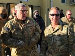 FILE - Chairman of the U.S. Joint Chiefs of Staff Gen. Mark Milley, left, talks with Gen. Scott Miller, the commander of U.S. and coalition forces in Afghanistan, at Miller’s military headquarters in Kabul, Afghanistan, Dec. 16, 2020.