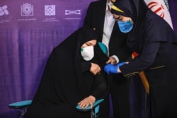 A woman receives an injection during the first trial phase of a locally-made Iranian vaccine for COVID-19 coronavirus disease in Iran's capital Tehran on Dec. 29, 2020.