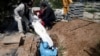 Iranian men bury the journalist Abdollah Zavieh, who passed away due to coronavirus disease (COVID-19), at Behesht Zahra cemetery in Tehran, March 24, 2020.