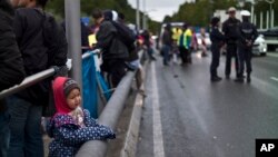 Une enfant syrienne pleure en attendant d'être transportée avec sa famille vers un centre d'hébergement pour refugiés à Freilassing en Allemagne (Septembre 2015) . 