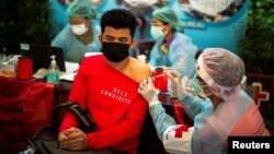 ထိုင်းနိုင်ငံရောက် ရွှေ့ပြောင်းအလုပ်သမားတဦးကို ကျန်းမာရေးဝန်ထမ်းက ကိုဗစ်ကာကွယ်ဆေး ထိုးပေးနေ။ 