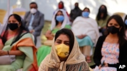 Faithful wearing face masks and maintain social distancing as a precaution against the coronavirus attend a Christmas Mass in Ahmedabad, India, Dec. 25, 2020. 