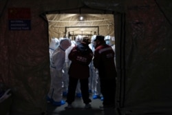 Medical workers in protective suits are seen at the Wuhan Parlor Convention Center, which is serving as a makeshift hospital following an outbreak of the novel coronavirus, in Wuhan, Hubei province, China, Feb. 7, 2020.