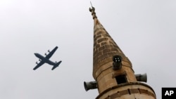 With a mosque's minaret in the foreground, a United States Air Force cargo plane takes off from Incirlik Air Base, on the outskirts of the city of Adana, southern Turkey, July 30, 2015. 