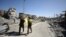 Combatientes de las furzas democráticas de Siria caminan por una calle de Raqqa, Siria, el martes, 17 de octubre de 2107.
