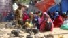 FILE - Somali families, displaced after fleeing the Lower Shabelle region amid an uptick in U.S. airstrikes, wait at an IDP (internally displaced person) camp near Mogadishu, Somalia, March 12, 2020.