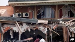 Investigators work at the site of a blast at a cafe in Marrakech, April 28, 2011