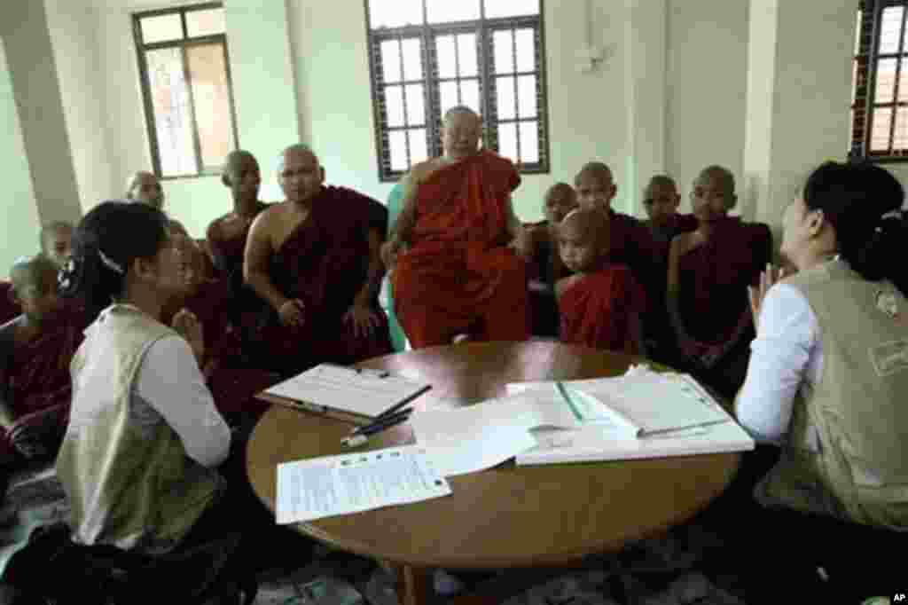 Myanmar census enumerators pay their respects to Buddhist monks while collecting information at a monastery in Dala township Sunday, March 30, 2014, in Yangon, Myanmar. Enumerators fanned out across Myanmar on Sunday for a census that has been widely cri