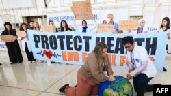 Los activistas medioambientales llevan a cabo una protesta con un globo terráqueo durante una manifestación en el lugar de la Cumbre del Clima de las Naciones Unidas COP28 en Dubái el 6 de diciembre de 2023.