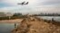 Israelis fish in the Mediterranean sea as aircraft prepares to land in Sde Dov airport in Tel Aviv, Nov. 24, 2013. 