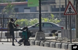 A police officer detains a protester near Lekki toll gate in Lagos, Nigeria. Authorities said more than 100 people who died in 2020 during protests against police brutality will soon be buried.