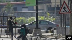 FILE - In this Oct. 21, 2020, file photo, a police officer detains a protester near Lekki toll gate in Lagos, Nigeria.