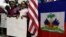 Children stand next to United States and Haitian flags as they hold signs in support of renewing TPS for immigrants from Central America and Haiti now living in the United States, during a news conference, Nov. 6, 2017, in Miami.