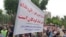 Dozens of retired and active Iranian teachers demonstrate outside Tehran's planning & budget office, May 10, 2018, to demand greater government funding for education. In this image provided to VOA Persian by an audience member, protesters hold a sign advocating free education for Iranian children. Iranian security forces later broke up the protest, beating and arresting several people.