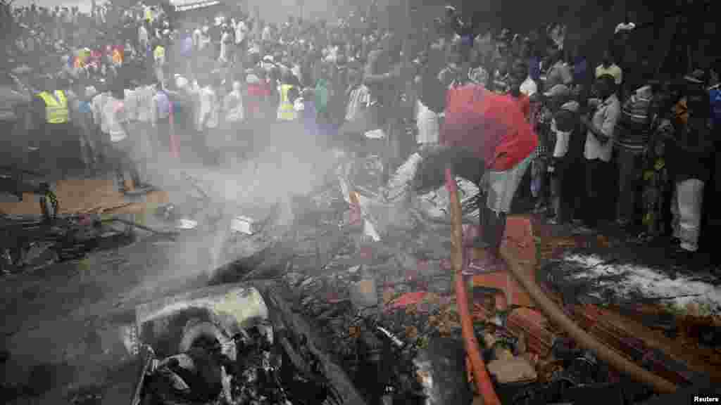 People gather at the site of a plane crash near Lagos airport.