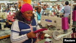 People work on machines at a clothing factory at an industrial town of Newcastle, 260 km (162 miles) southeast of Johannesburg, May 8, 2013.