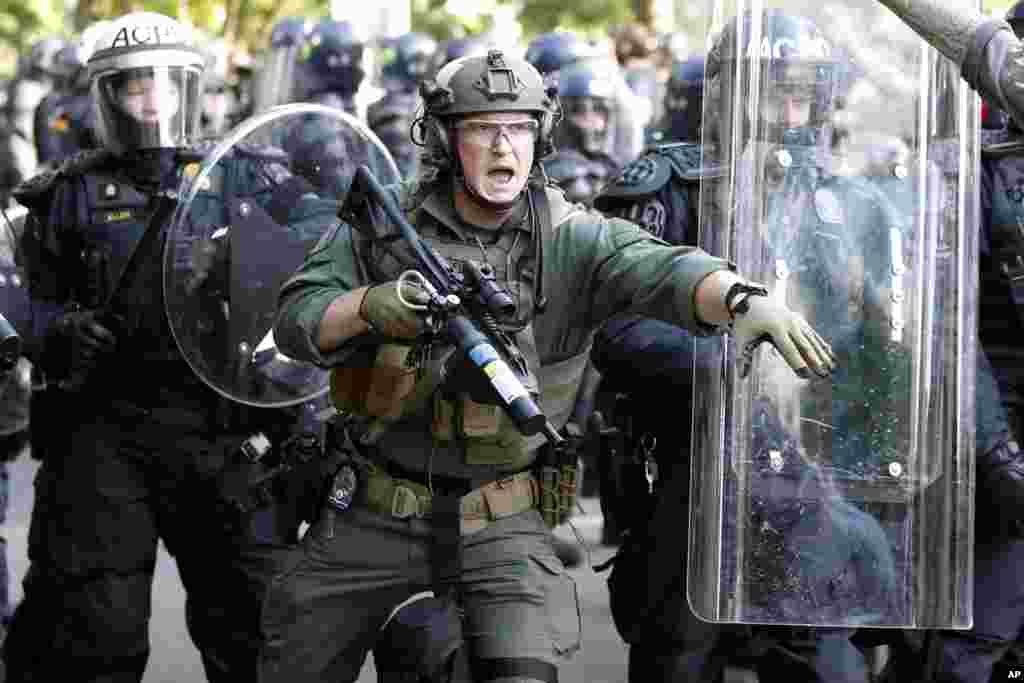 Police begin to clear demonstrators gathered as they protest the death of George Floyd, June 1, 2020, near the White House in Washington.