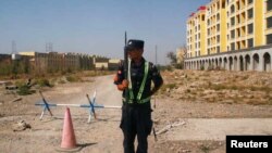 中国警察在新疆维吾尔自治区伊宁市称为职业教育中心附近的道路上执勤。