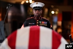 Marine Staff Sgt. Nayya Dobson-EL stands as part of the Guard of Honor at the flag-draped casket of former President Jimmy Carter as he lies in repose at the Jimmy Carter Presidential Library and Museum in Atlanta, Georgia, Jan. 4, 2025.