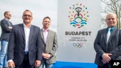 President of the Hungarian Olympic Committee Zsolt Borkai, left, Chairman of the Budapest 2024 bid Balazs Furjes, second left, and Budapest Mayor Istvan Tarlos, right, pose in front of the logo of host city candidate Budapest for the 2024 Olympic and Par