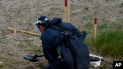 Un detector de minas busca minas antitanques en Lypivka, en las afueras de Kiev, el 14 de junio del 2022.