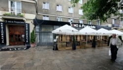 FILE - A man walks in front of the now-closed restaurant Sowa &amp; Przyjaciele, June 20, 2014 , where top Polish politicians and business people were secretly and illegally recorded over hundreds of hours in 2013 and 2014, in Warsaw, Poland.