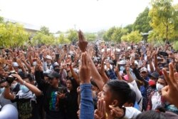 Supporters give the three-finger salute during Mya Thwate Thwate Khaing's funeral, in Naypyitaw, Myanmar, Feb. 21, 2021. She was the first confirmed death among the many thousands who have taken to the streets to protest the Feb. 1 coup.