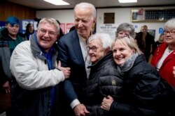 Democratic presidential candidate former Vice President Joe Biden takes a photo with members of the audience at a campaign stop at the American Legion Post, Jan. 30, 2020, in Ottumwa, Iowa.