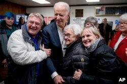 Democratic presidential candidate former Vice President Joe Biden takes a photo with members of the audience at a campaign stop at the American Legion Post, Jan. 30, 2020, in Ottumwa, Iowa.