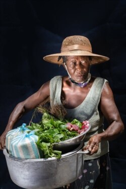 Claudette compró carne fresca, espinacas y arroz en el mercado local con su dinero en efectivo del PMA. También compró ollas para cocinar para preparar una gran comida caliente para su nieto Cavensley, quien perdió a sus padres. PMA / Antoine Vallas.