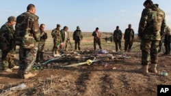 FILE - Kurdish Peshmerga forces inspect a site in Hardan village in northern Iraq where Islamic State fighters allegedly executed people from the Yazidi sect captured when they swept through the area in August.