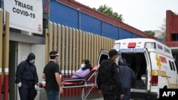 Paramedics move a patient suspected of having contracted the coronavirus, at a COVID-19 triage area at the General Hospital in Mexico City, Mexico, August 20, 2020. 