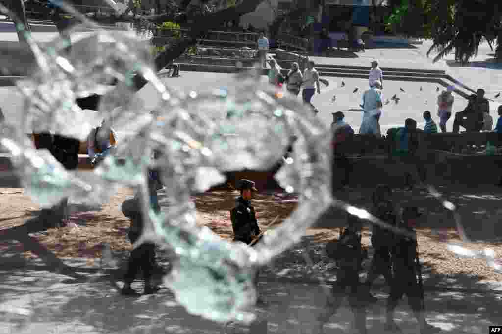 Soldiers patrol the central square, where most shopfront windows were damaged during the protests by sympathizers of the Opposition Alliance Against the Dictatorship over the inauguration the day before of President Juan Orlando Hernandez, in Tegucigalpa, Honduras, Jan. 28, 2018.